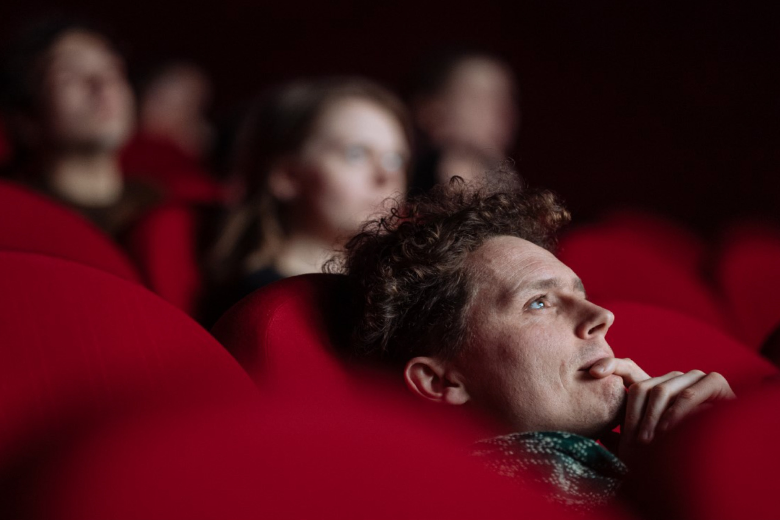Divák v kině zaujatě sleduje film