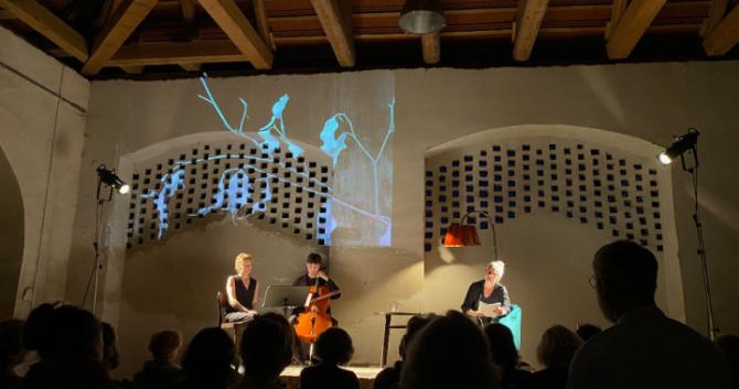 Tři osoby hrají na různé nástroje v prostoru půdy divákům.